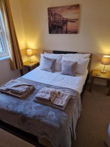 a bedroom with a bed with two towels on it at Harbour View apartment in Portreath in Portreath