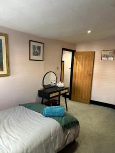 a bedroom with a bed and a table with a mirror at Bishopric Cottage 2 Bedroom Cottage In Horsham Built In 1667 in Horsham