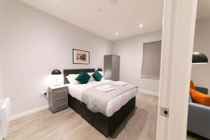 a bedroom with a large bed with green pillows at Convenient 2 Bed Apartment in Waterloo Liverpool in Waterloo