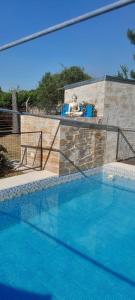 a large swimming pool with a bear sitting on a ledge at CABAÑAS HORNERO in San José del Rincón +17 photos