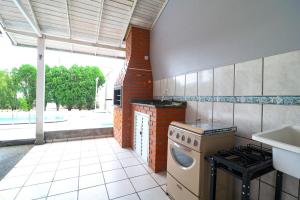 a kitchen with a stove and a sink at Nete Getaway! in Palhoça