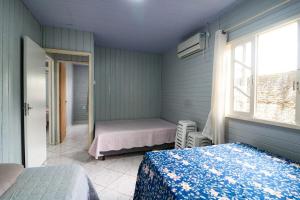 a room with two beds and a window and a window at Nete Getaway! in Palhoça