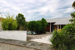 a house with a fence in front of a yard at Nete Getaway! in Palhoça