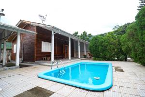 a blue tub sitting on a patio next to a house at Nete Getaway! in Palhoça