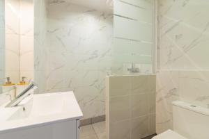 a white bathroom with a sink and a shower at Appartement moderne et élégant Michel Torrent 2 in Perpignan +14 photos