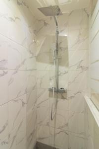 a shower in a bathroom with white marble walls at Appartement moderne et élégant Michel Torrent 2 in Perpignan
