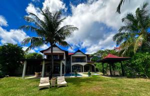 a house with a palm tree in front of it at Spas Villas Eden Island in Victoria