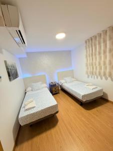 a room with two beds in a room at Hostal Quinta Santillan in San Fernando de Henares