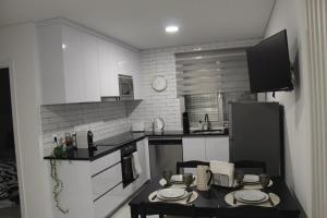 a kitchen with a table and a black refrigerator at Alojamento Mondinense in Mondim de Basto