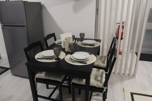 a black table with chairs and plates and a refrigerator at Alojamento Mondinense in Mondim de Basto +11 photos