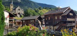 a group of buildings and a church in a village at Chez Sophie Aletsch - Binntal in Grengiols