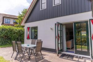 a patio with a table and chairs in front of a house at Buitenplaats 105 in Callantsoog +9 photos