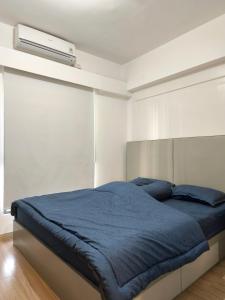 萨姆波罗Sky House BSD 3 Bedroom 70m2 View Pool Dan Garden的卧室里有一张床，床铺是蓝色的