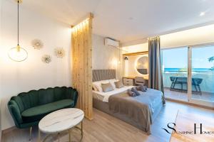 sypialnia z łóżkiem i zieloną kanapą w obiekcie Seaview beachfront studio with aqua park & balcony w mieście Benalmádena