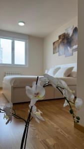 a bedroom with a bed and a vase with white flowers at Apartamentos Suites Iscar in Iscar