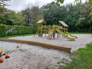 a playground with a slide in the sand at Camping de Beukenhof in Tiendeveen