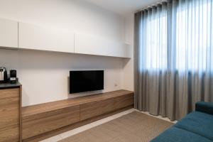 a living room with a tv and a blue couch at Appartamenti "Primula - Fiordaliso" - Cascina Da Rosa in Capiago Intimiano