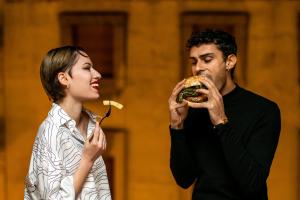 a man and a woman eating a sandwich at The Modernist Hotel in Trieste
