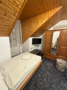a bedroom with a large bed and a television at Panzió Pér in Pér
