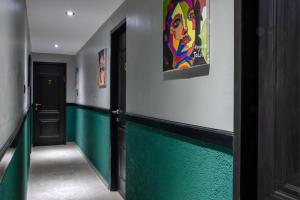 埃拉特אשראם אילת的走廊上设有绿色和白色的墙壁和绘画作品
