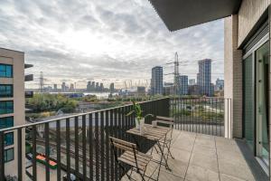 a balcony with a table and chairs and a view of the city at Waterview apartments with ultra fast wifi close to Excel and O2, corporates and contractors welcome in London