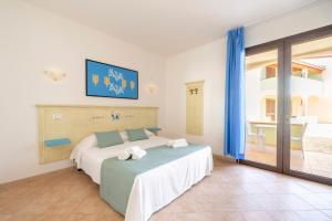 a bedroom with a bed with towels on it at Mimose Beach Village in Badesi +94 photos