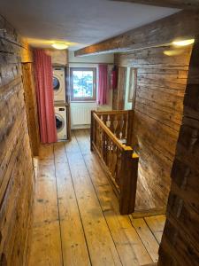 a room with a wooden floor and stairs in a house at Uriges Alpen-Apartment Juen Stefan in See