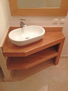 a white sink on a wooden counter in a bathroom at Stone House Apartments in Brtonigla