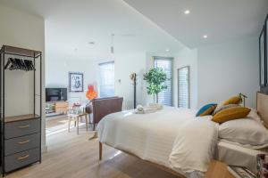 a bedroom with a large bed and a living room at Fabulous Central Apt With Balcony & Parking in Cambridge