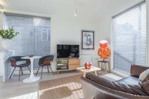a living room with a couch and a table at Fabulous Central Apt With Balcony & Parking in Cambridge