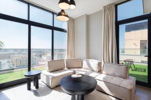 シャルジャにあるLuxury 1BR Penthouse in Sharjah with Skyviewsのソファと大きな窓のあるリビングルーム +32枚の写真