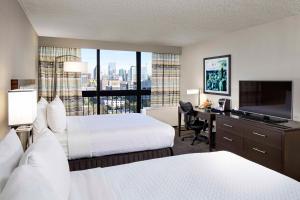 a hotel room with two beds and a desk with a television at Crowne Plaza Atlanta Midtown, an IHG Hotel in Atlanta