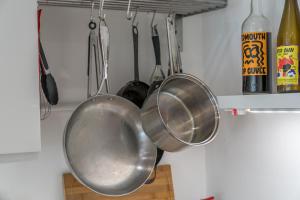 a bunch of pots and pans hanging in a kitchen at Waterview apartments with ultra fast wifi close to Excel and O2, corporates and contractors welcome in London