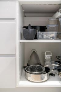a kitchen shelf with dishes and bowls on it at Waterview apartments with ultra fast wifi close to Excel and O2, corporates and contractors welcome in London