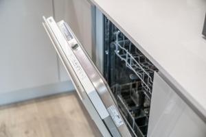 a dishwasher with its door open in a kitchen at Waterview apartments with ultra fast wifi close to Excel and O2, corporates and contractors welcome in London