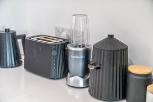 a blender sitting on a counter next to a container at Waterview apartments with ultra fast wifi close to Excel and O2, corporates and contractors welcome in London