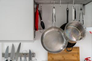 a pan hanging from a rack in a kitchen at Waterview apartments with ultra fast wifi close to Excel and O2, corporates and contractors welcome in London