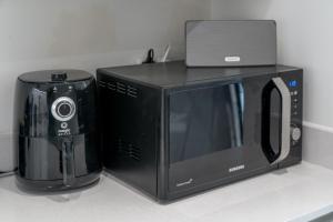 a microwave and a toaster oven on a counter at Waterview apartments with ultra fast wifi close to Excel and O2, corporates and contractors welcome in London