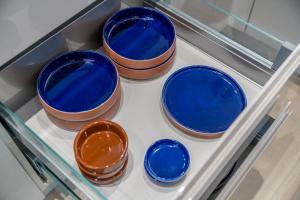 a group of blue bowls on a shelf in a drawer at Waterview apartments with ultra fast wifi close to Excel and O2, corporates and contractors welcome in London