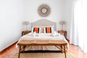 a white bedroom with a large bed with orange pillows at Villa in Comporta Village with heated pool in Comporta +100 photos