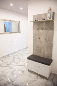 a room with a bench on a wall with a mirror at Bulevar Apartman BL in Banja Luka +2 photos