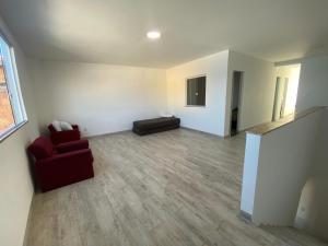 a living room with a red couch and a chair at Casa de praia Jacuipe Condomínio Planeta Água 1 in Campos