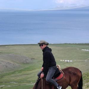 a man riding on the back of a horse at Yurt camp KEREMET in Kyzart