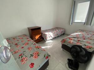 a room with two twin beds and a fan at Casa de praia Jacuipe Condomínio Planeta Água 1 in Campos +10 photos