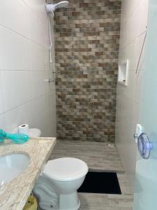 a bathroom with a toilet and a sink and a shower at Casa de praia Jacuipe Condomínio Planeta Água 1 in Campos