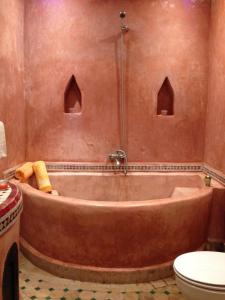 a bath tub in a bathroom with a toilet at Riad Hiba in Marrakesh