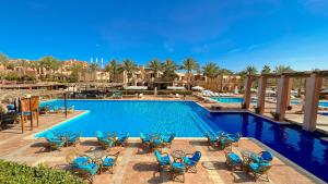 a swimming pool with blue chairs and a swimming pool at Tamra Beach Resort in Sharm El Sheikh