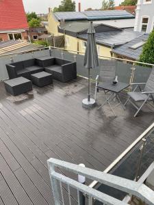 an outdoor deck with an umbrella and furniture on a house at FEWO Backbord Huus & Meer in Fehmarn