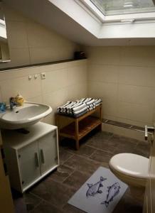 a bathroom with a sink and a toilet at FEWO Backbord Huus & Meer in Fehmarn