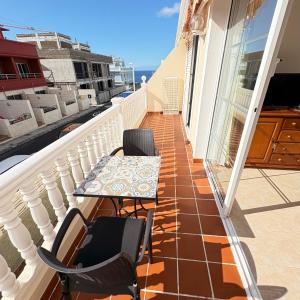 a balcony with a table and chairs on it at Apartamento Wanda junto al MAR in Puerto Naos